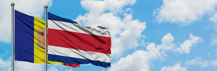 Andorra and Costa Rica flag waving in the wind against white cloudy blue sky together. Diplomacy concept, international relations.