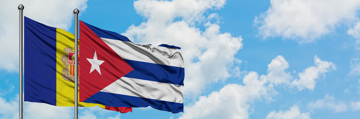 Andorra and Cuba flag waving in the wind against white cloudy blue sky together. Diplomacy concept, international relations.