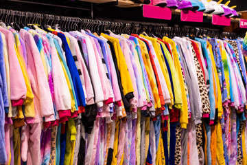 kigurumi colorful pajamas for children hanging on a shop counter 