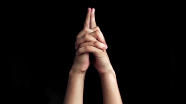 A single human hand comes up and shows Matangi Yoga Mudra or Gesture Of The Goddess Matangi isolated on a black background.