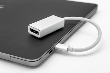 Isolated view of a MDP display adapter seen connected to a well-known laptop and digital lifestyle manufacture. Used for connected to external displays.