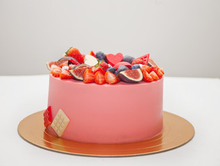 Cake with chocolate smudges, decorated berries and fruits