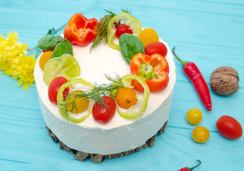 Appetizing cake with chicken meat, eggs and salad. Snack unsweetened cake. Wooden board with hot peppers and tomatoes.