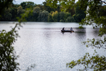 Fototapeta na wymiar Two men fishing on a lake in Berlin