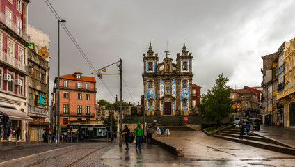 A square in Porto in the rain and an old church, Portugal - obrazy, fototapety, plakaty
