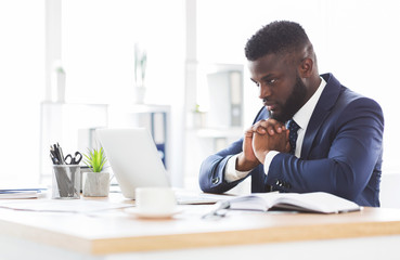 Concentrated african american man working with laptop in office