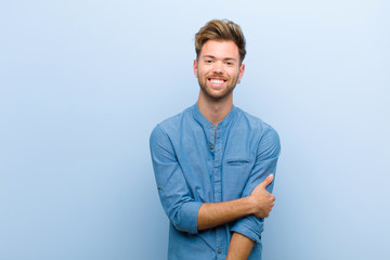 young businessman laughing shyly and cheerfully, with a friendly and positive but insecure attitude...