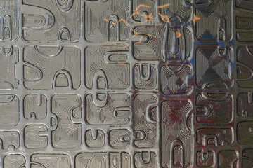 Repetitive backtround formed by a close-up of an antique art-deco window pane with lines and symbols var 3