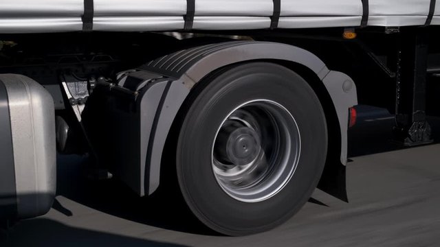 Cargo is transported by large truck, large car carries trailer, cross-country driving, slow overtaking, city supply, smooth highway, large-diameter wheels, intercity transportation, carries food
