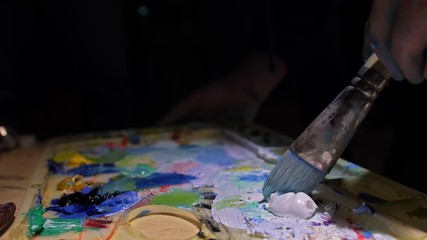 Artist copyist paint seascape with ship in ocean. Craftsman decorator draw as boat sail on blue sea with acrylic oil color. Draw finger brush palette.