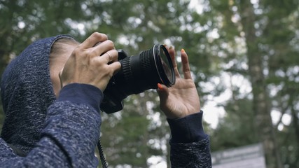 Traveler photographing scenic view in forest. One caucasian woman shooting close up look. Girl take photo video on dslr mirrorless camera.