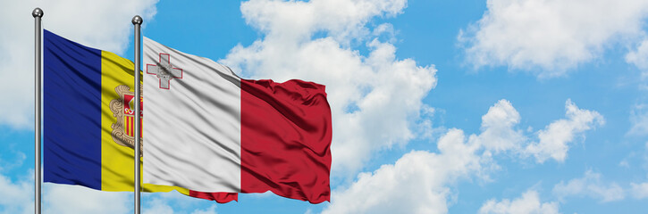Andorra and Malta flag waving in the wind against white cloudy blue sky together. Diplomacy concept, international relations.
