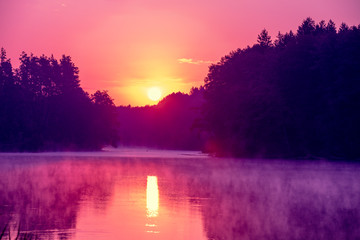 Magical sunrise over the lake with a beautiful reflection on the water. Serene lake in the early...