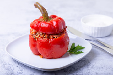 Peppers stuffed with meat, rice and vegetables with tomato sauce and sour cream. A traditional dish. Close-up.