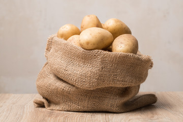 Sack of potatoes studio image. Full bag of potatoes. Burlap sack with potatoes.