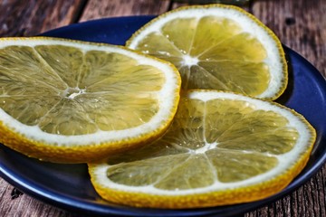 Lemon slices in a saucer on a wooden background