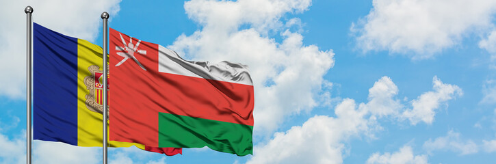 Andorra and Oman flag waving in the wind against white cloudy blue sky together. Diplomacy concept, international relations.