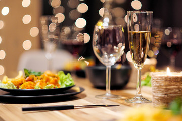 Festive table setting. Food and drinks, plates and glasses. Evening lights and candles. New Year's...