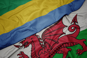 waving colorful flag of wales and national flag of gabon.