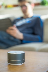 Smart ai speaker with child playing on tablet in the backround.  Smart home concept