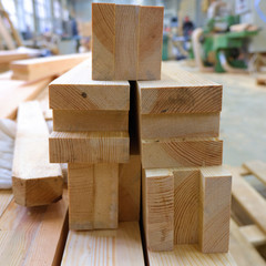 View from butt of stack of three-layer wooden glued laminated timber beams from pine finger joint...