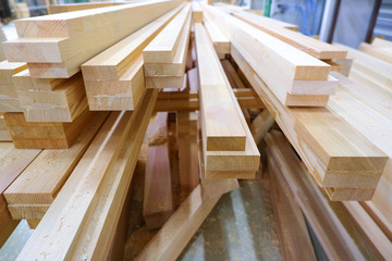 View from butt of stack of three-layer wooden glued laminated timber beams from pine finger joint spliced boards