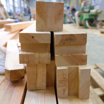 View from butt of stack of three-layer wooden glued laminated timber beams from pine finger joint spliced boards