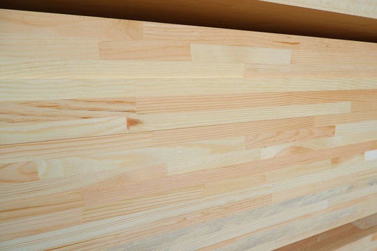 Side view of stack of three-layer wooden glued laminated timber beams from pine finger joint spliced boards