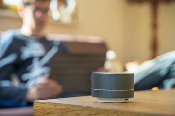 Smart ai speaker with child playing on tablet in the backround.  Smart home concept