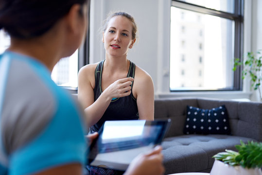 Chinese woman physiotherapist talking to a mid-adult caucasian f