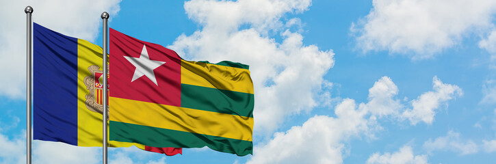 Fototapeta na wymiar Andorra and Togo flag waving in the wind against white cloudy blue sky together. Diplomacy concept, international relations.