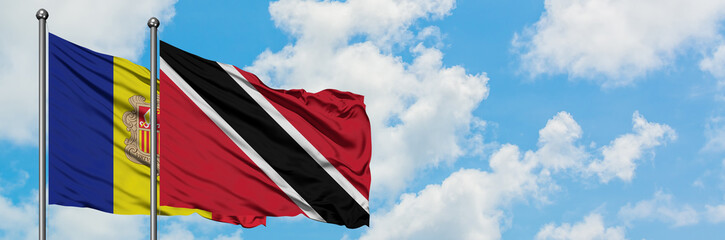 Andorra and Trinidad And Tobago flag waving in the wind against white cloudy blue sky together. Diplomacy concept, international relations.