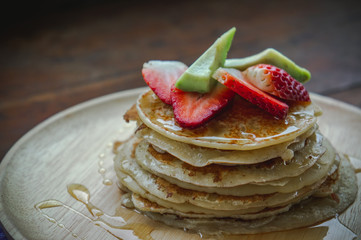 pancake strawberry avocado fruit and honey syrup sweeet dessert homemade and ready to eat on wood table.