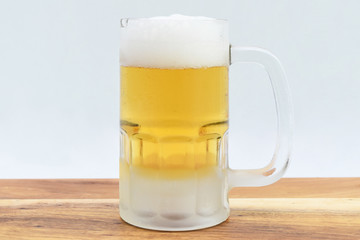 Cold beer mug on wooden board