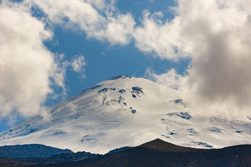 Fototapeta na wymiar Sky with clouds over the snowy peak of Mount Elbrus, North Caucasus.
