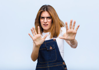 young pretty woman feeling terrified, backing off and screaming in horror and panic, reacting to a...