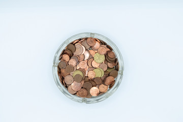 Euro cent coins in a glass ashtray. Financial concept.