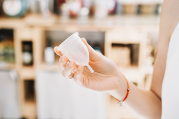 Woman hands holding menstrual cup in zero waste shop