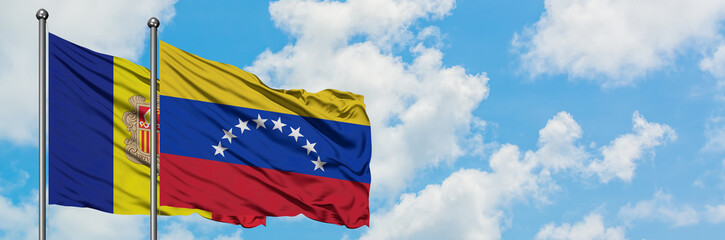 Andorra and Venezuela flag waving in the wind against white cloudy blue sky together. Diplomacy concept, international relations.