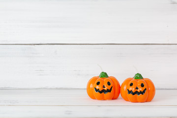 Orange candle pumpkin on white wooden background with copy space ,  halloween concept.