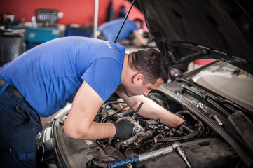 Two car mechanic repairers service technician repairs auto engine