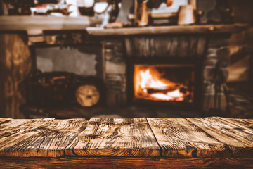 Table top with fireplace background in cozy home interior.