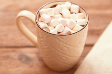 Fototapeta na wymiar A Cup of traditional Christmas hot chocolate or cocoa with marshmallows on a wooden table, close-up, top view