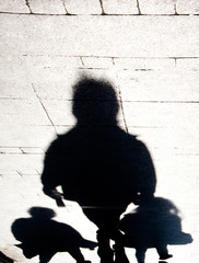 Blurry shadow silhouette of people walking on city street sidewalk - 297374341