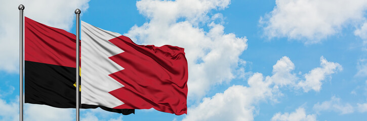 Angola and Bahrain flag waving in the wind against white cloudy blue sky together. Diplomacy concept, international relations.