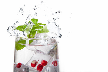 summer pomegranate drink with lemon and mint with splashed water and ice