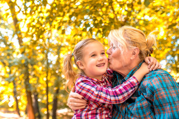 Grandmother and granddaughter spending time together in autumn park