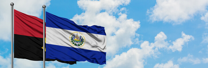 Angola and El Salvador flag waving in the wind against white cloudy blue sky together. Diplomacy concept, international relations.