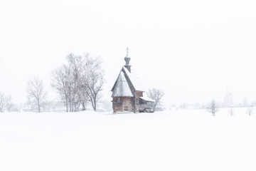 Fototapeta na wymiar Small wooden church in the snowy silence