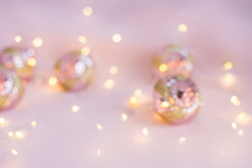 light pink background blurred with Christmas lights and toys